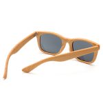Wood-like sunglasses with grey lenses and light wooden frames, featuring a logo on the side.
