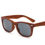 Wood-like sunglasses with dark lenses and a rich brown frame, featuring a logo on the side.