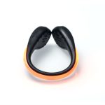 An LED clip-on shoe light in black with an orange light strip, featuring a curved design.