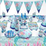 A set of customised disposable party tableware featuring mermaid designs in blue and pastel colours, including cups, plates, and decorations.