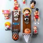 A wall-mounted bottle opener decorated with various figurines, including basketball and soccer themes, in vibrant colours.