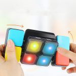 A handheld, multicoloured Luminous Cube featuring bright lights in red, yellow, and blue with a black frame.