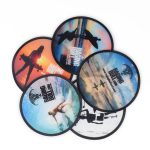 A set of six folding flying discs featuring vibrant, scenic designs in various colours and a logo.