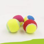 Four dog tennis balls in bright colours including yellow, pink, red, green, and blue, featuring a logo.