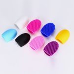 A set of silicone makeup brush cleaners in various colours: white, blue, black, pink, purple, and yellow.