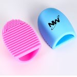 A silicone makeup brush cleaner in pink and blue, featuring text branding on one side and textured surfaces for cleaning.