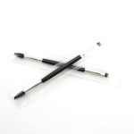 A double-headed eyebrow brush with a black handle and clear packaging, featuring a spoolie and angled brush.