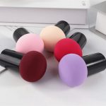 Mushroom Head Powder Puff collection with six puffs in colours including pink, red, purple, and beige, each with a black handle.