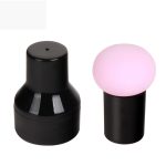 A black product container alongside a pink mushroom-shaped puff, promoting beauty and personal care use.