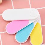 A nail file set featuring four files in pink, blue, yellow, and white, with a white casing and a logo.