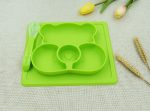A green, bear-shaped non-slip children's plate with three compartments and a matching spoon.