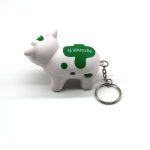 A white and green milk cow stress key chain with a keyring attached.