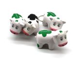 A set of four white and green milk cow stress key chains, each with a keyring and a logo.