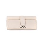 A cream-coloured makeup brush holder with a clasp closure and logo displayed on the front.