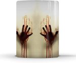 A coffee mug featuring heat-sensitive colour changing design with bloodied handprints on a light background.