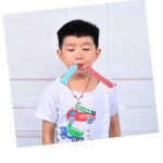 A child holds two colourful party whistles, one blue with polka dots and one red with polka dots, in their mouth.
