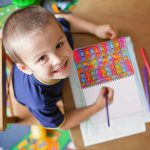 A5 Pop Bubble Fidget Notebook featuring colourful pop bubbles on the cover, with a child using it to draw.