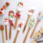 A set of festive baking spatulas featuring Christmas designs, including a snowman, Santa, and holiday patterns, with wooden handles.