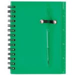 A green spiral notebook featuring a pen attached, with a ruler printed along the side.