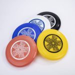 A set of five Ultimate Frisbees in red, blue, white, black, and yellow, featuring a star design and a logo.