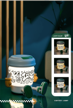 A coffee cup-shaped lamp and Bluetooth speaker in white and green, featuring playful doodle art, sits on a reflective surface.