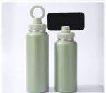 A drink bottle in matte green, featuring a magnetic lid and a circular handle, displayed in two sizes.