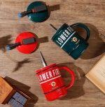 A drink mug in the shape of a fire extinguisher, featuring red and green colours and a logo.