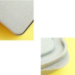 A wheat straw bread box in light green with a speckled design, featuring a subtle logo on the lid.