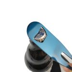 A drink bottle opener tool in metallic blue is removing a bottle cap from a dark glass bottle.