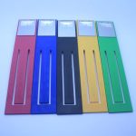 A set of five foldable book lights in red, blue, black, yellow, and green, featuring a reflective top section and holes for light.