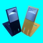 A foldable book light in black and yellow, featuring a rectangular light at the top and a sturdy base.