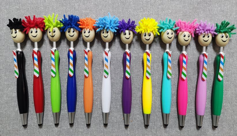 A collection of colourful stylus pens with playful, fuzzy-haired tops, featuring various bright colours and cheerful faces. A collection of colourful stylus pens with playful, fuzzy-haired tops, featuring various bright colours and cheerful faces.