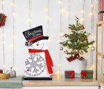 A festive snowman calendar ornament in white, with a black hat, red scarf, and a snowflake design.