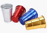 A set of four rolled edge aluminum cups in silver, red, blue, and gold, featuring a shiny finish and a logo.