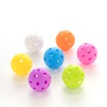 A set of seven pickleballs in vibrant colours: pink, blue, yellow, green, orange, white, and purple. Each ball has holes and a glossy finish.