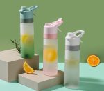 A drink bottle trio in pastel colours: green, pink, and grey, featuring citrus slices and a logo on each.