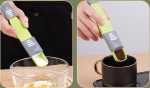 An adjustable measuring spoon in green and grey, held over a bowl and a cup, showcasing its versatile measurements.