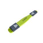 An adjustable measuring spoon in green and grey with measurement markings and a logo.