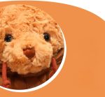 A plush brown teddy bear with a soft, curly texture and a cute face. The image features a circular crop with a logo.