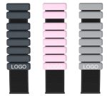 A collection of silicone weighted bracelets in black, pink, and grey, each displaying a logo.