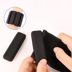 A silicone weighted bracelet with three black weights, being held and adjusted on a wrist.