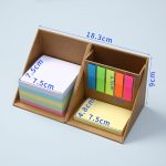 A desk organiser featuring pastel sticky notes and vibrant flags in a triangular cardboard holder.
