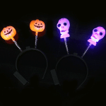 Flashing LED headband with orange pumpkin and purple skull decorations, featuring a spring attachment.