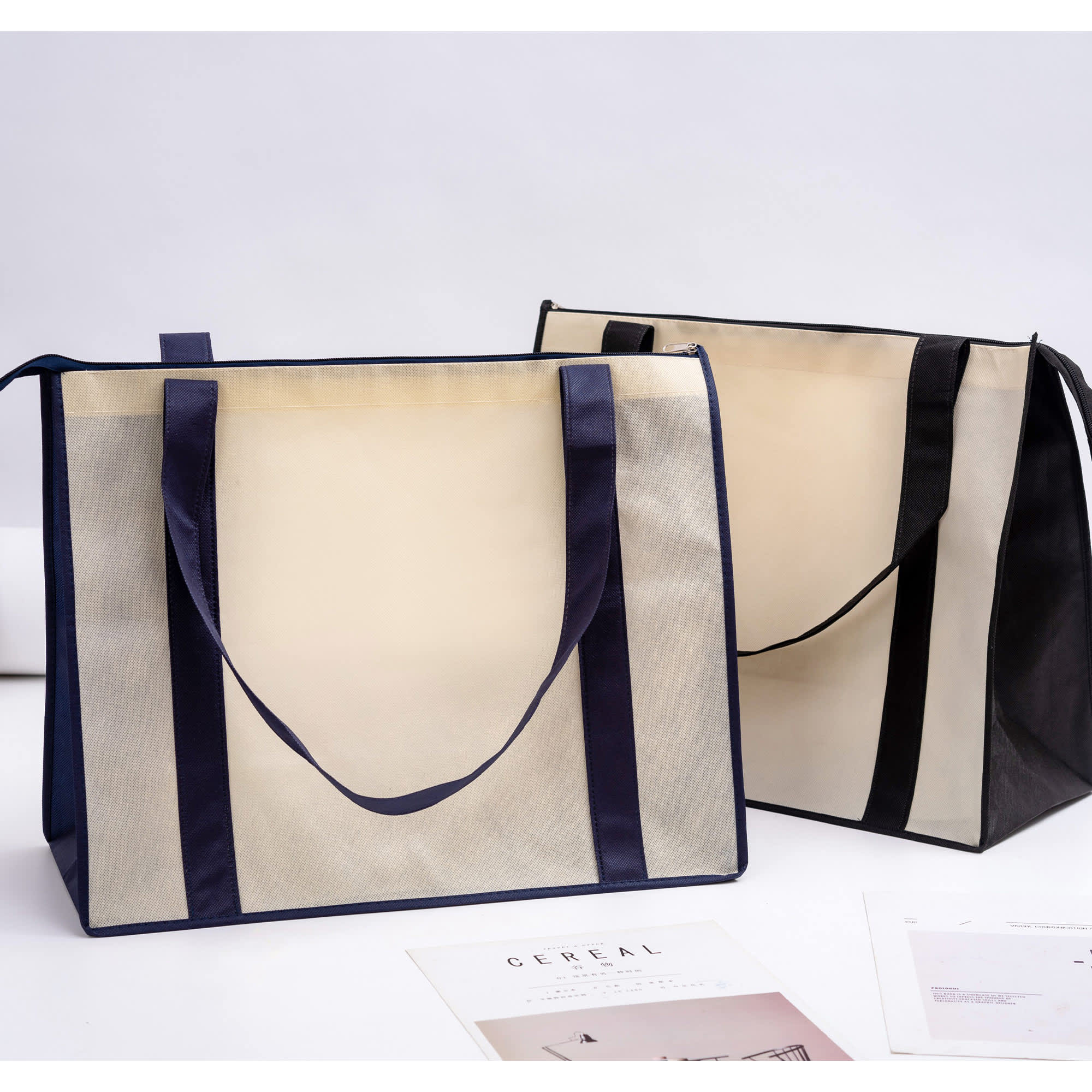 Two large zipped shopping bags in beige and black, featuring handles and a branding logo. Non Woven Large Zipped Shopping Bag - Image 1