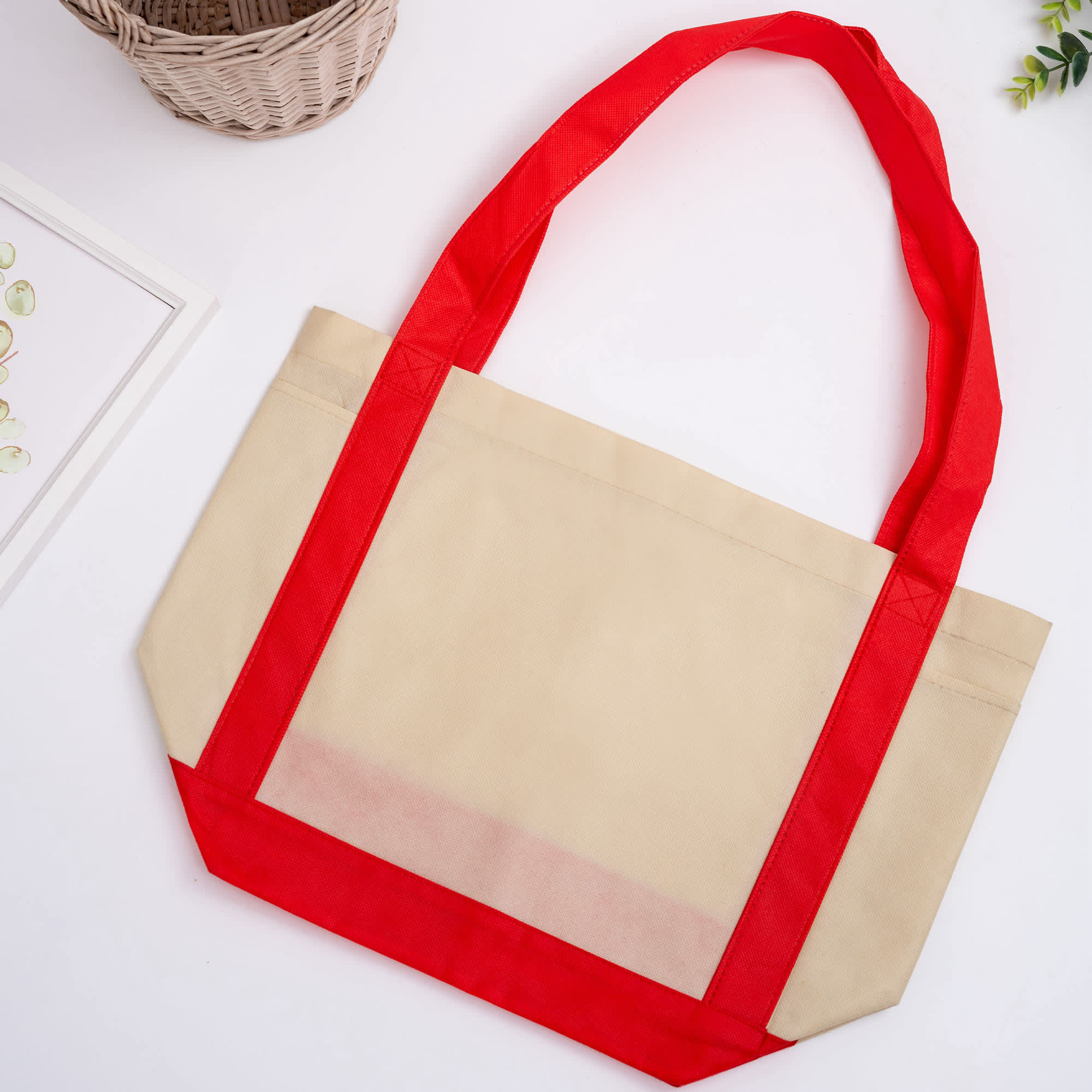 A large non-woven shopper bag in beige with red handles and accents. Features one logo on the front. Non Woven Larger Shopper - Image 1