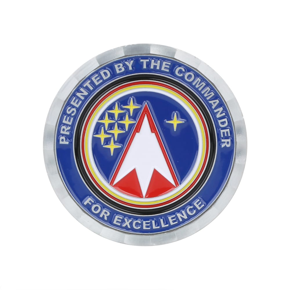 A round commemorative gold coin pin featuring a starry design and a red arrow symbol against a blue background. Commemorative Gold Coin - Image 1