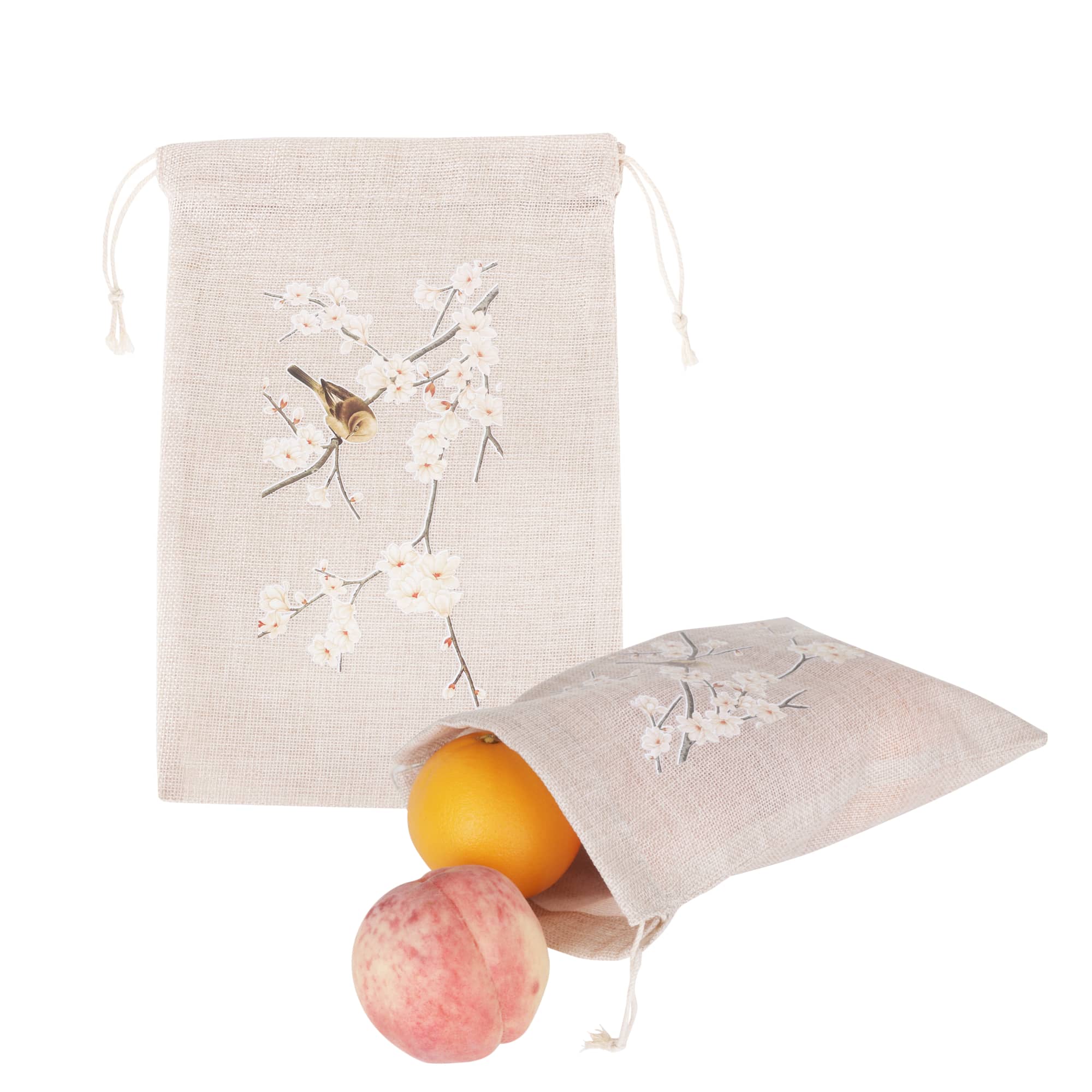 A small beige jute produce bag with floral designs, containing an orange and a pink apple. Small Jute Produce Bag - Image 1