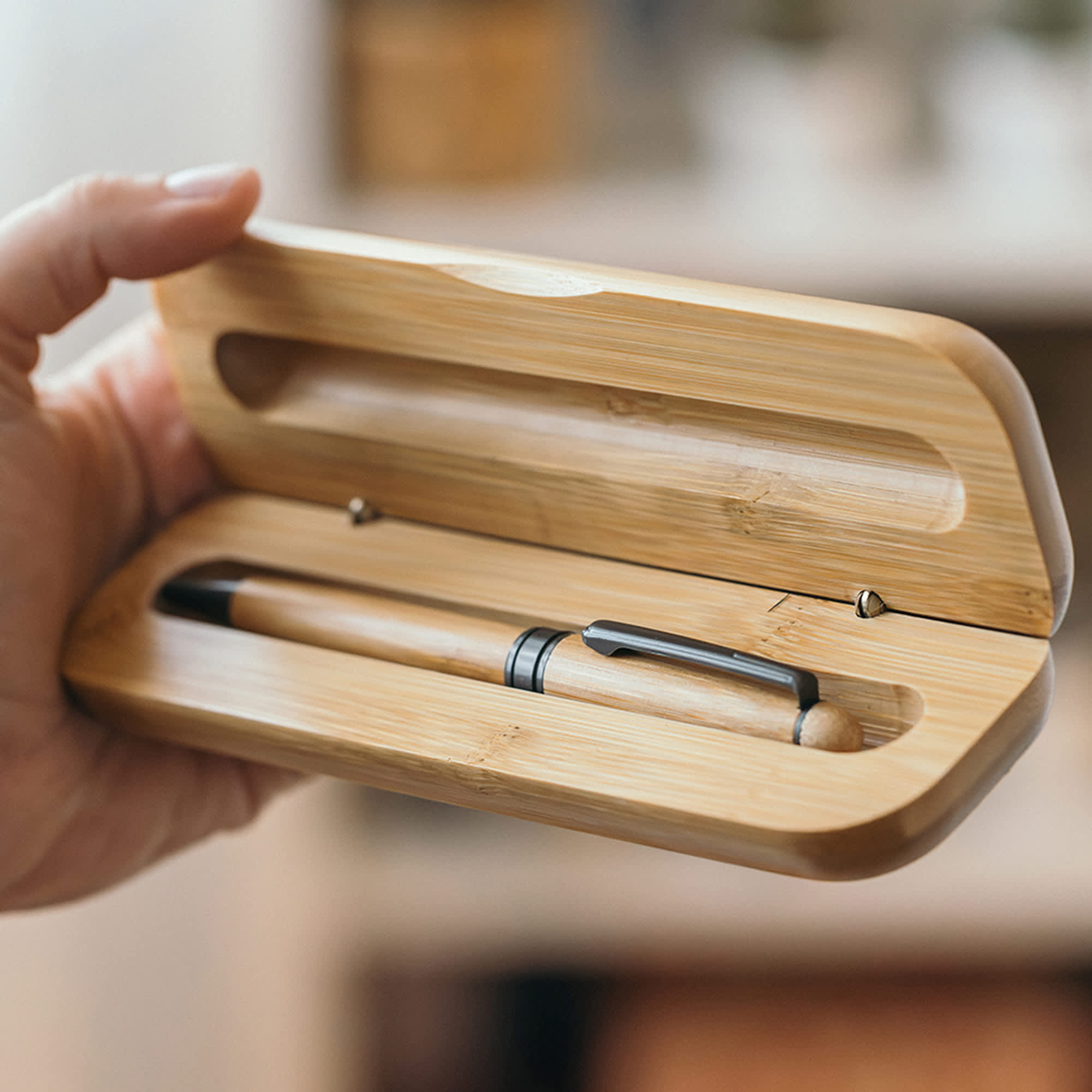 A bamboo case holding a natural wood pen with a silver clip, featuring a smooth, minimalist design. Bamboo Single Deluxe Presenter - Image 1