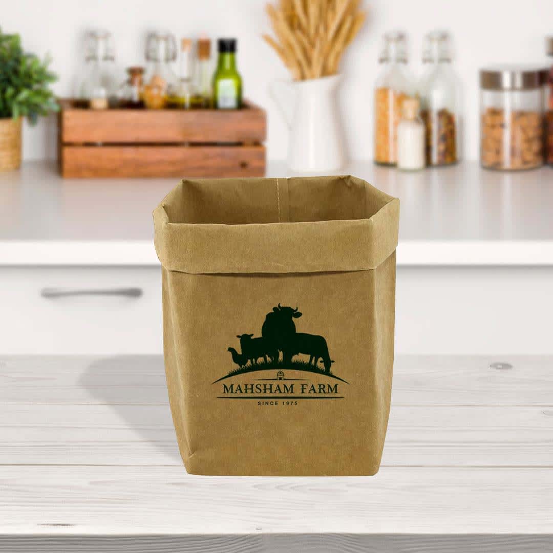 A large kraft paper storage bag in brown, featuring a logo, placed on a kitchen countertop with various jars. Sewo Kraft Paper Storage Bag – Large - Image 1