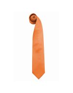 An orange fashion tie, rolled neatly, featuring a smooth texture and a pointed end.